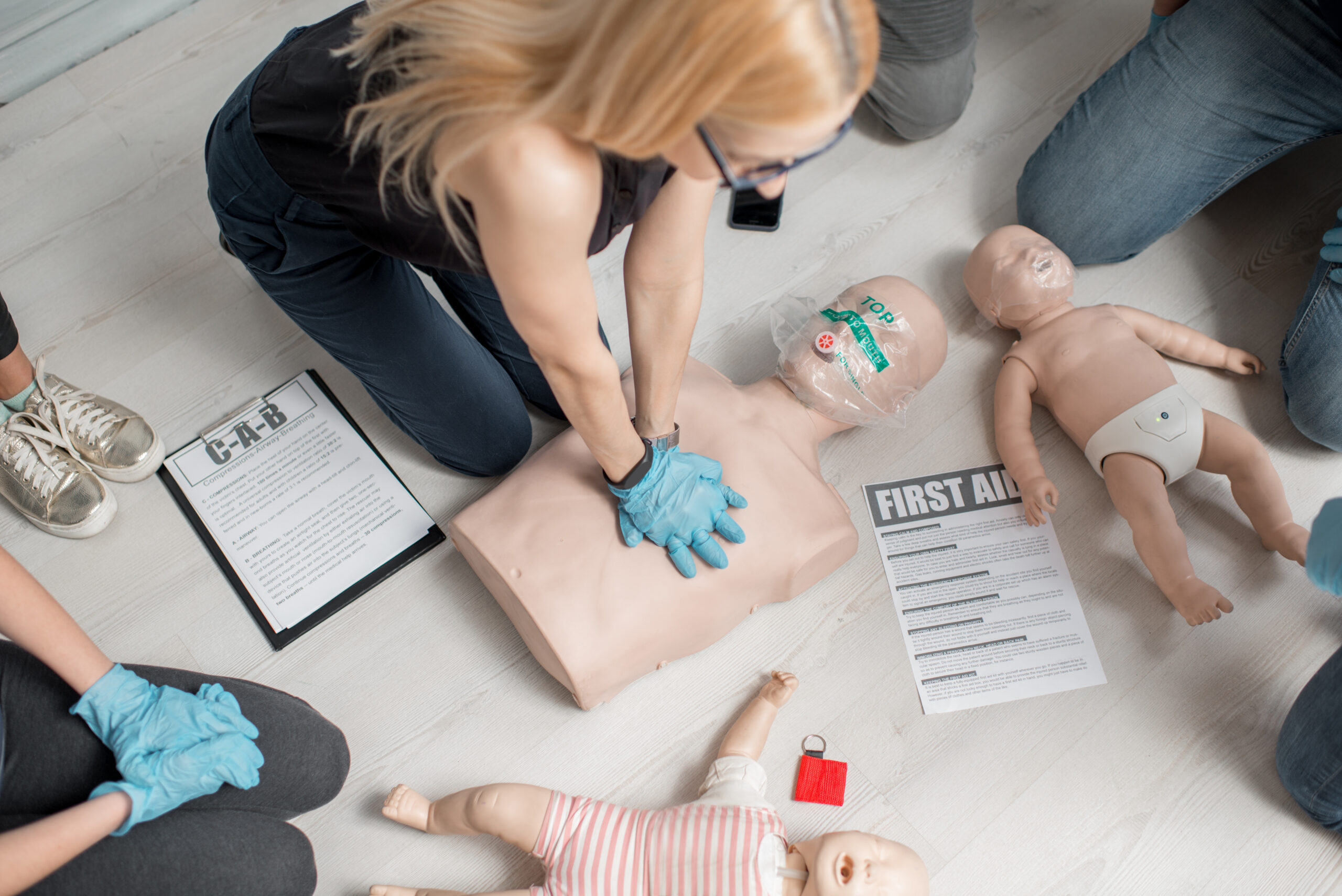 Formation d'un groupe de personnes aux gestes de premiers secours au travail et au massage cardiaque avec des mannequins d'entraînement