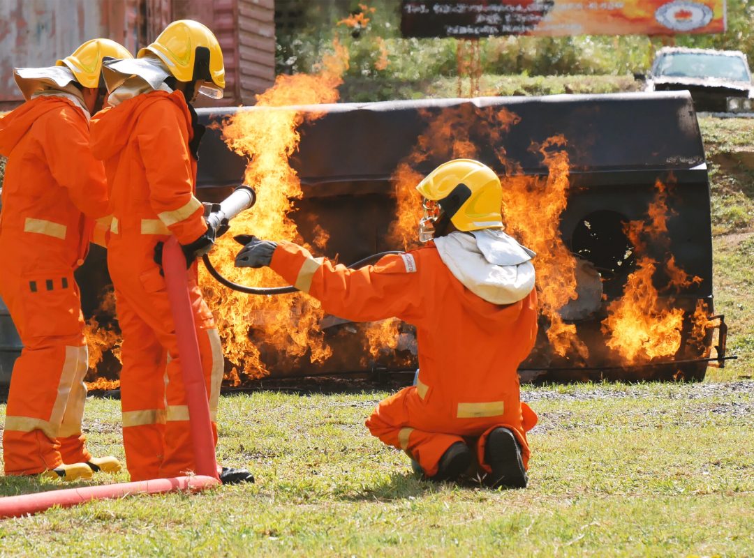 Employés formés s'entraînant avec des lances à incendies, des sprays et avec un équipement dédié sur un feu maîtrisé
